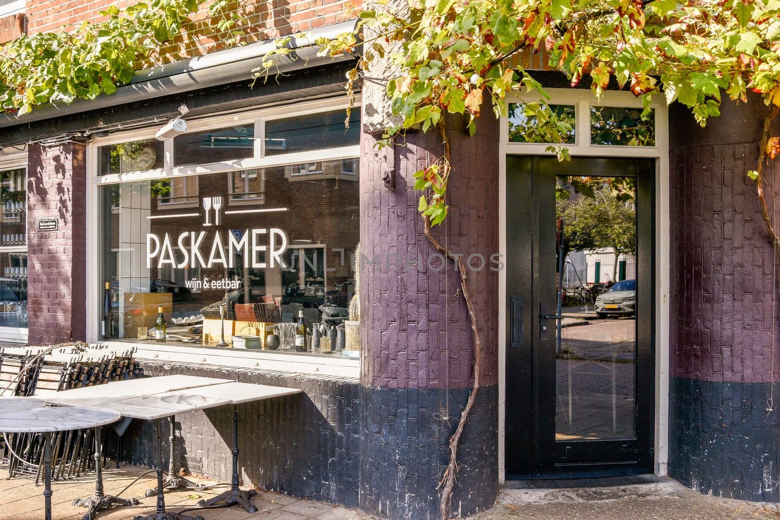 A quaint cafe exterior featuring outdoor seating amidst lush greenery. The rustic architecture and inviting atmosphere attract passersby for a relaxing cafe experience.