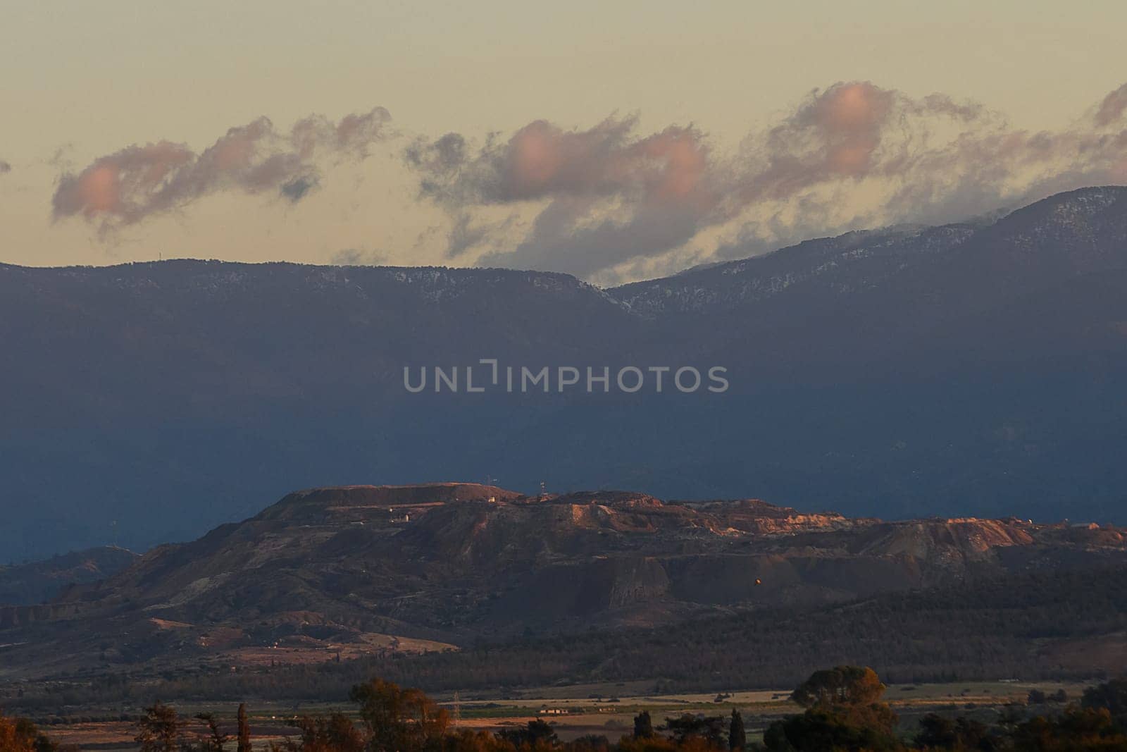 As twilight descends, a breathtaking mountain range comes alive with hues of lavender and pink.