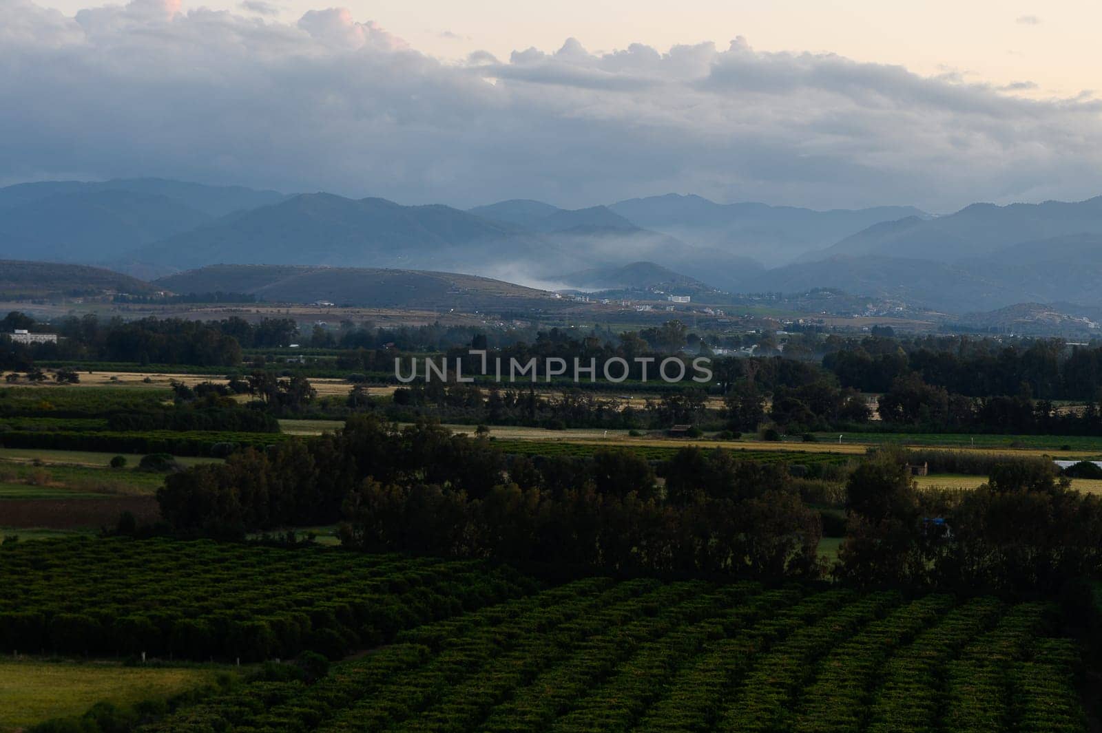 Golden light filters through the clouds as evening descends upon the valley.