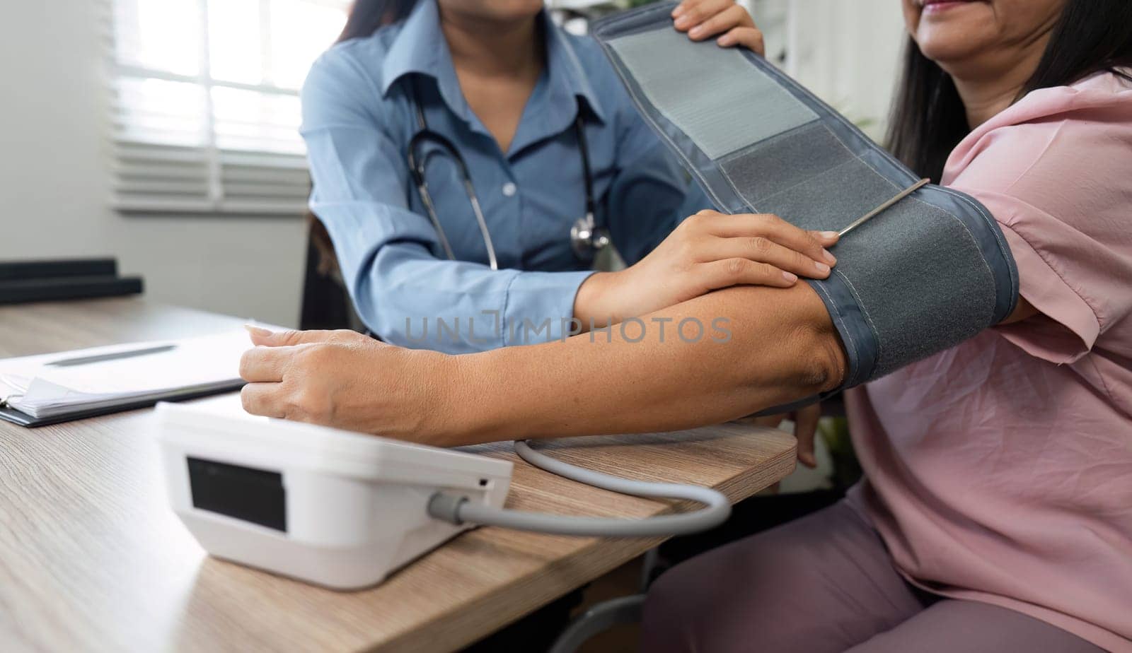 A nursing professional skillfully takes the blood pressure of an elderly patient, ensuring accurate readings and support during the consultation.