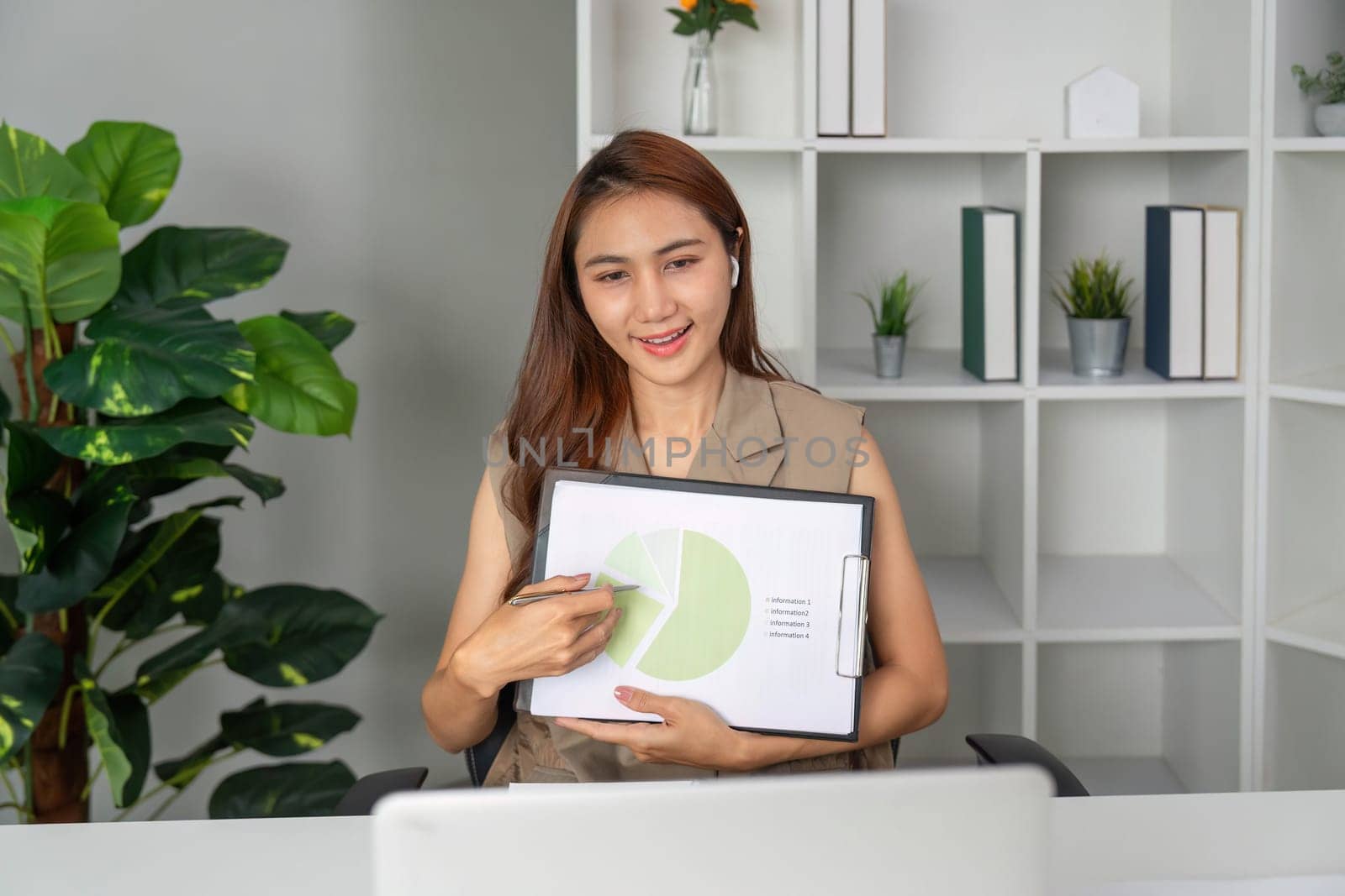 A businesswoman explains statistics using a pie chart during a video call, showcasing professional communication skills and teamwork in action.