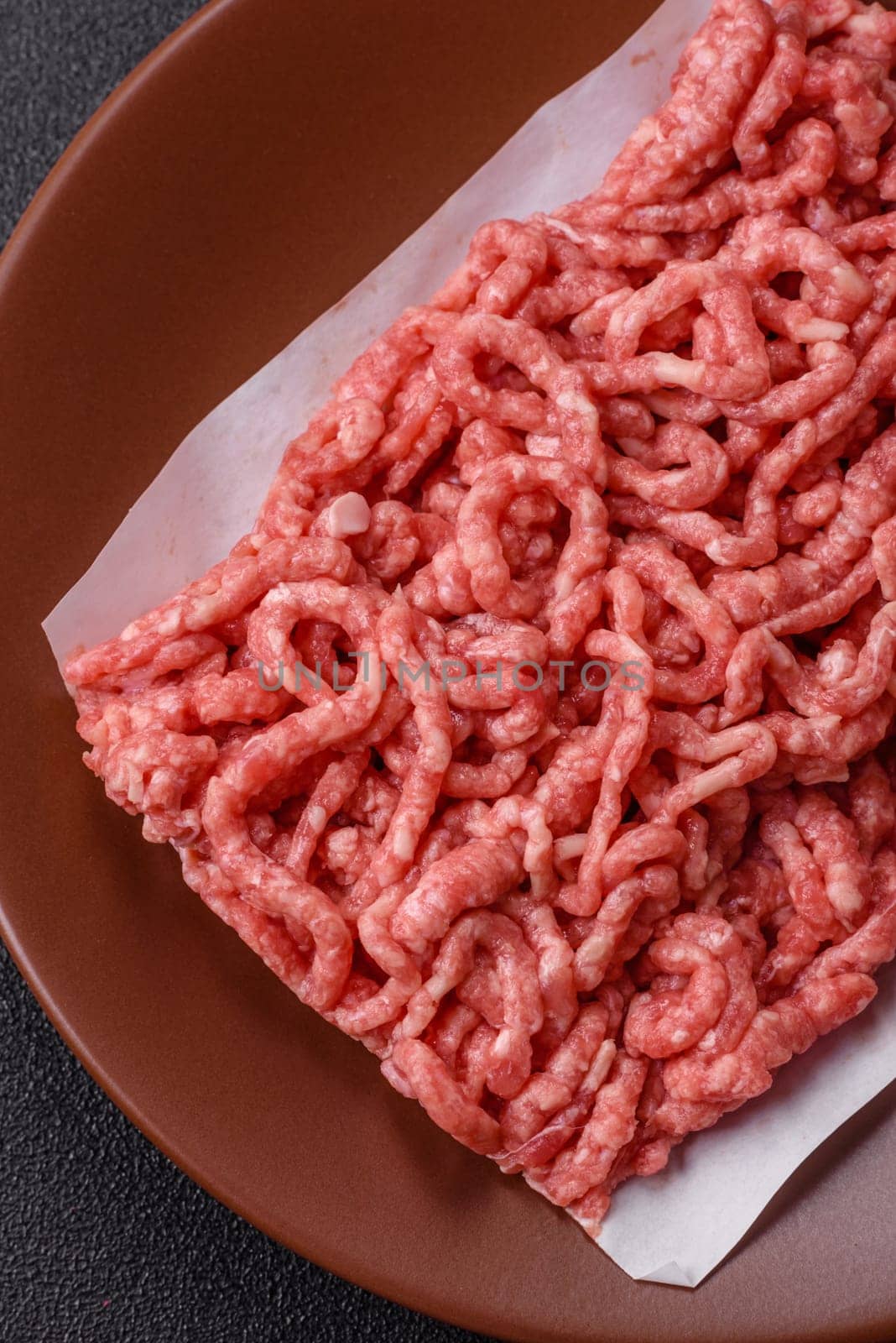Stuffing or ground raw beef or pork with salt and spices on a black background
