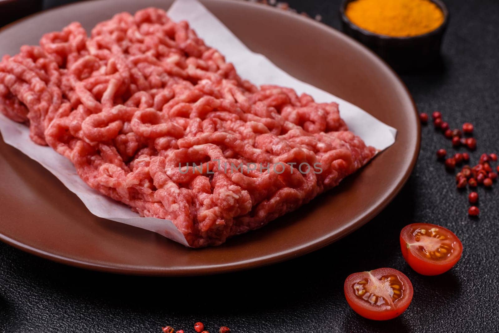 Stuffing or ground raw beef or pork with salt and spices on a black background