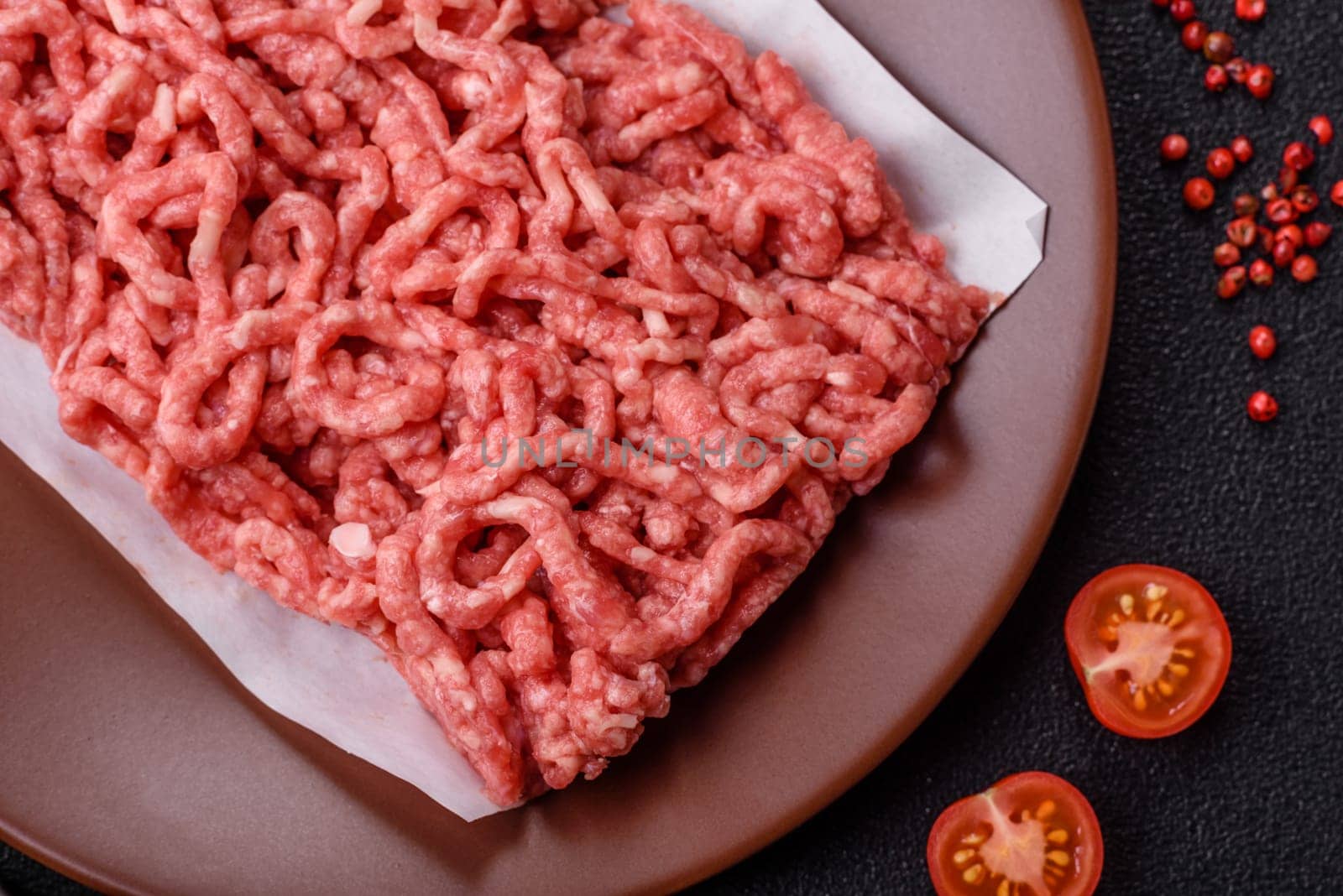 Stuffing or ground raw beef or pork with salt and spices on a black background
