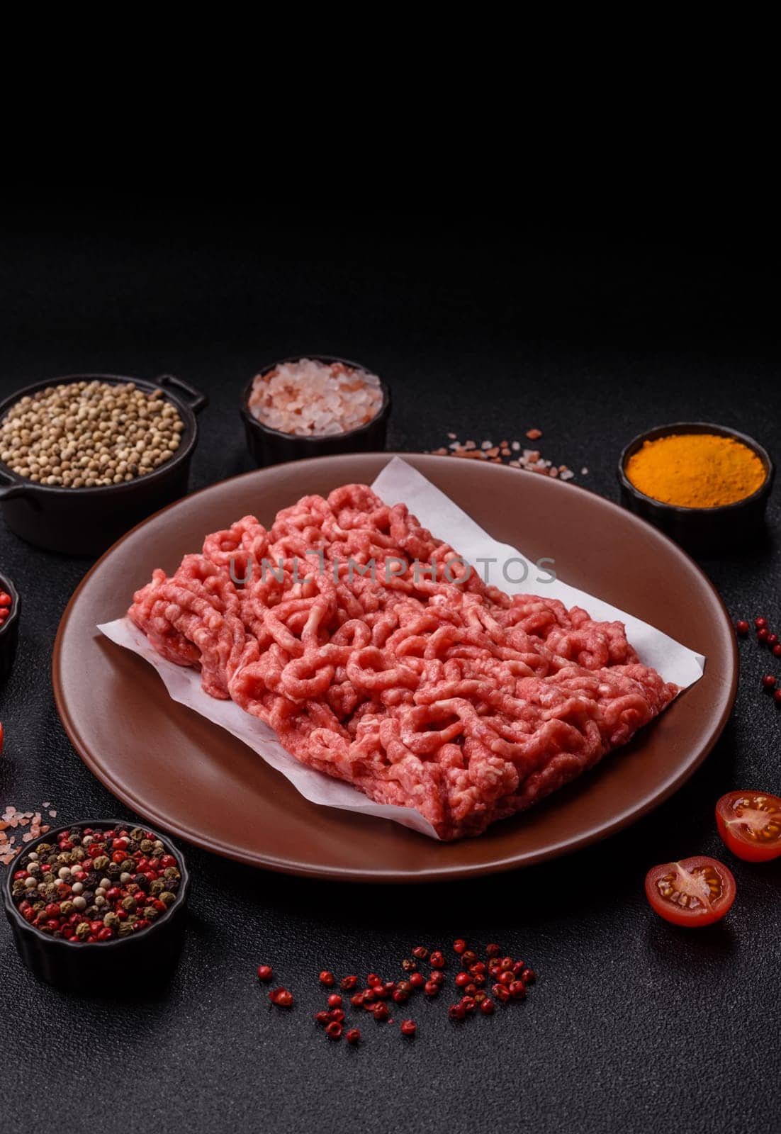 Stuffing or ground raw beef or pork with salt and spices on a black background