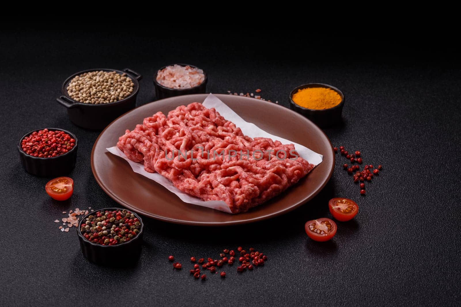 Stuffing or ground raw beef or pork with salt and spices on a black background