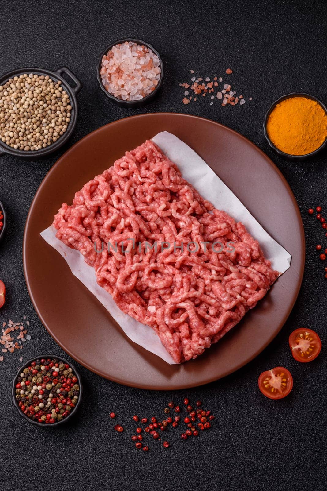 Stuffing or ground raw beef or pork with salt and spices on a black background
