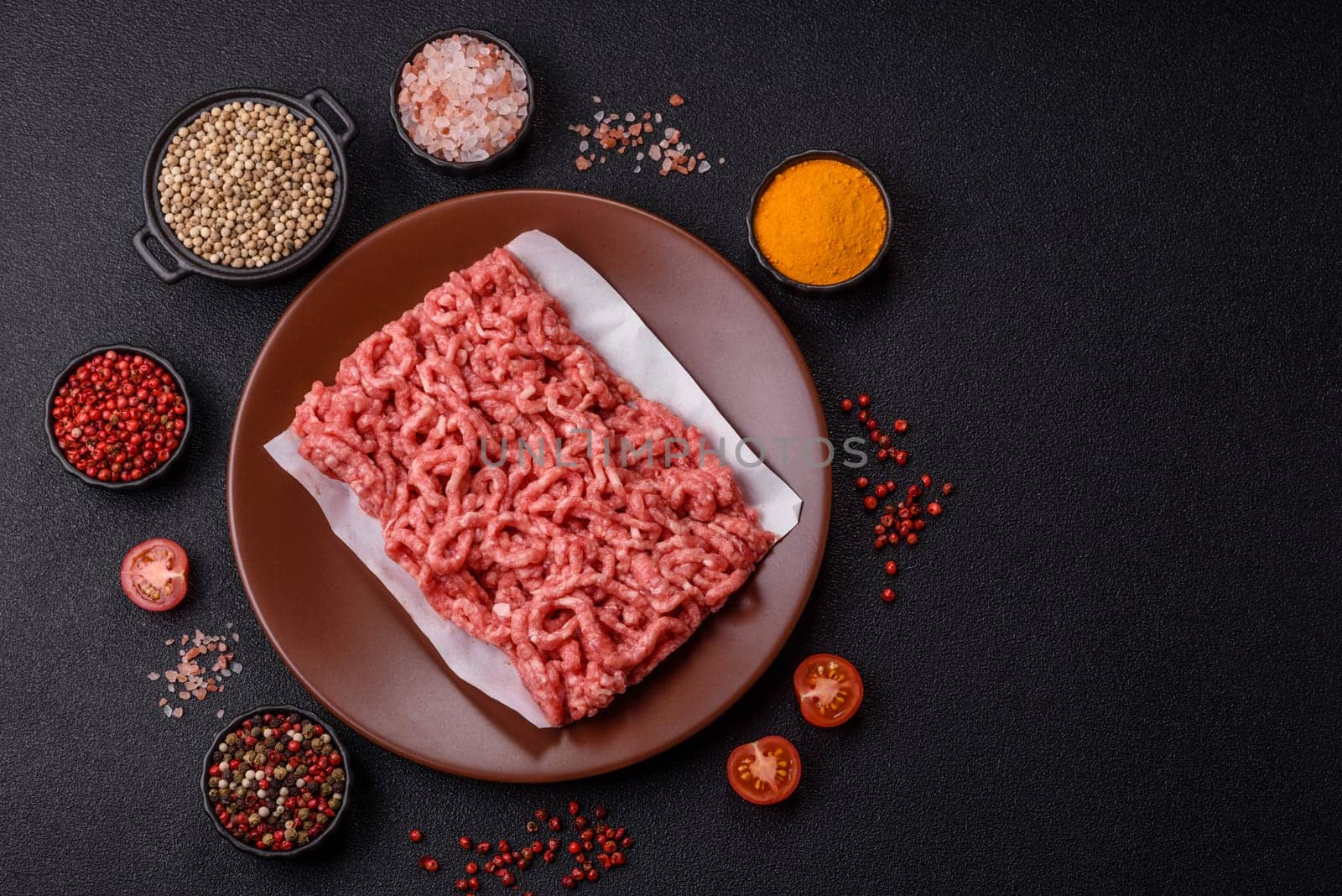 Stuffing or ground raw beef or pork with salt and spices on a black background