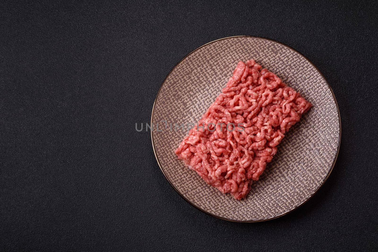 Stuffing or ground raw beef or pork with salt and spices on a black background