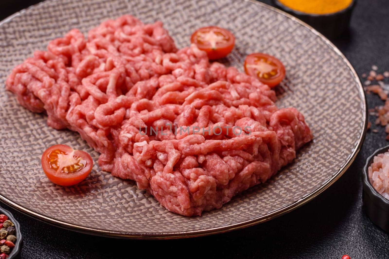 Stuffing or ground raw beef or pork with salt and spices on a black background