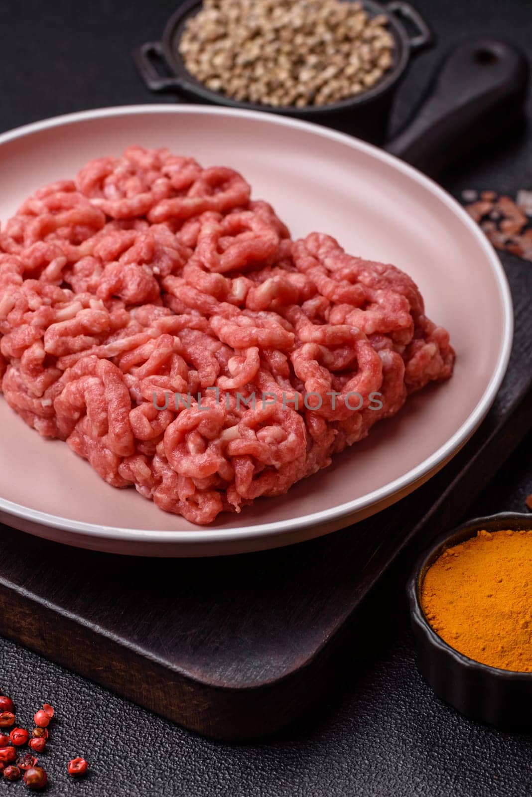 Stuffing or ground raw beef or pork with salt and spices on a black background