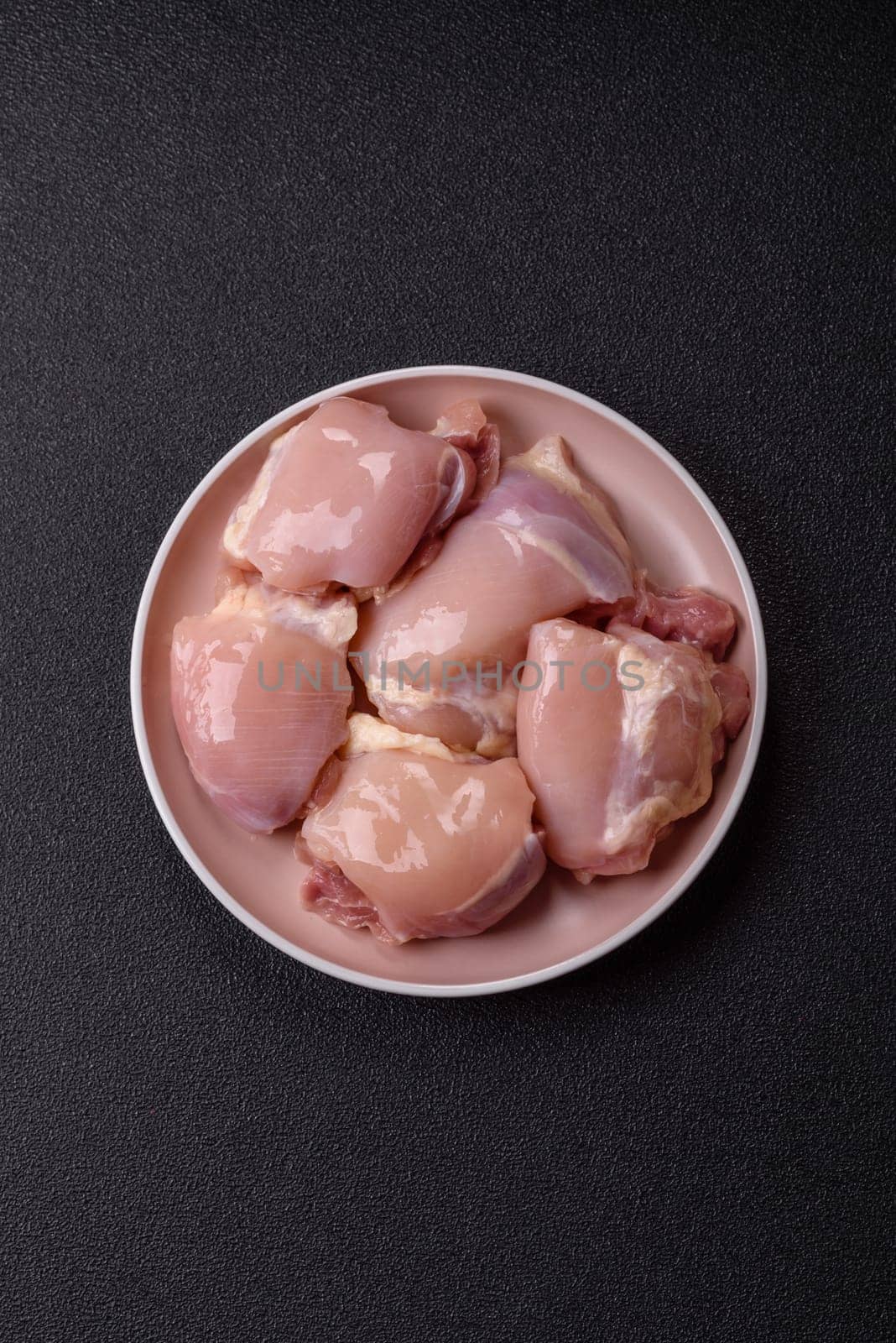 Chicken thigh fillet raw, skinless, boneless, poultry legs with salt and spices