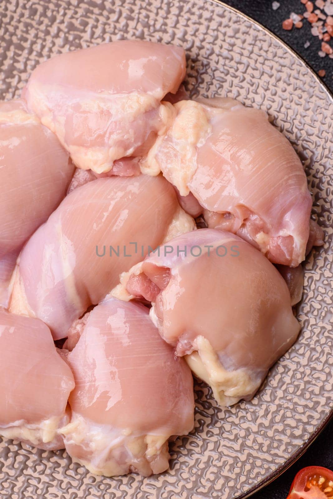 Chicken thigh fillet raw, skinless, boneless, poultry legs with salt and spices