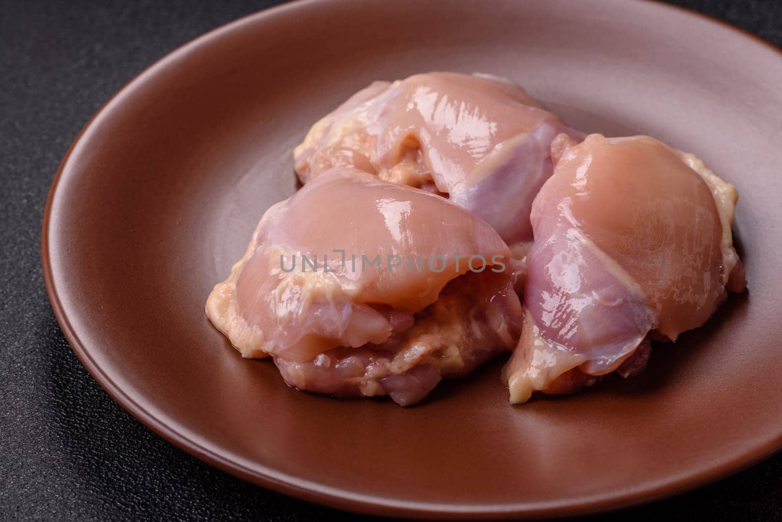 Chicken thigh fillet raw, skinless, boneless, poultry legs with salt and spices