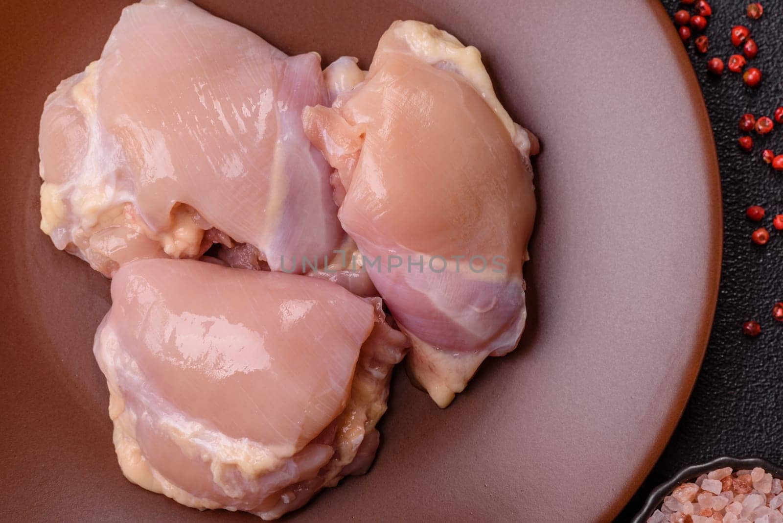 Chicken thigh fillet raw, skinless, boneless, poultry legs with salt and spices