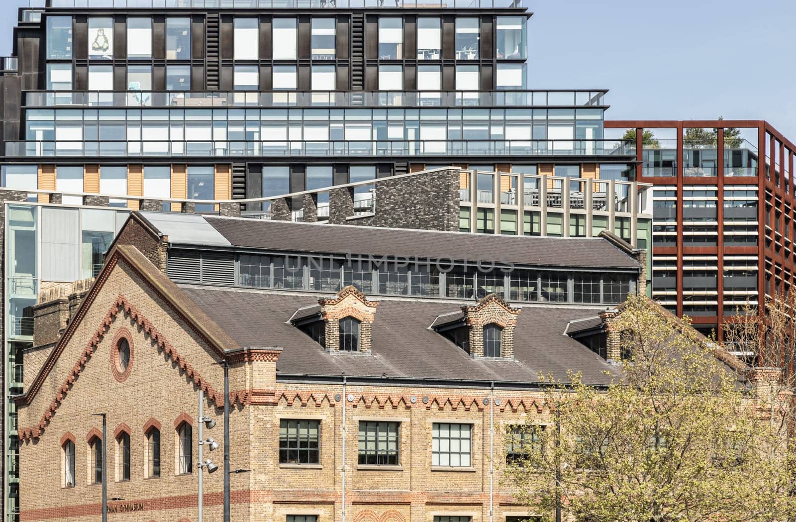 London, UK - Apr 11, 2025 - Exterior view of The German Gymnasium and One Pancras Square with with Skyscrapers background in the City of London. Architectural of Historic Building and New building in Contrasting Classical and Modern. use it as your Wallpaper, Poster and Space for text, Selective focus.