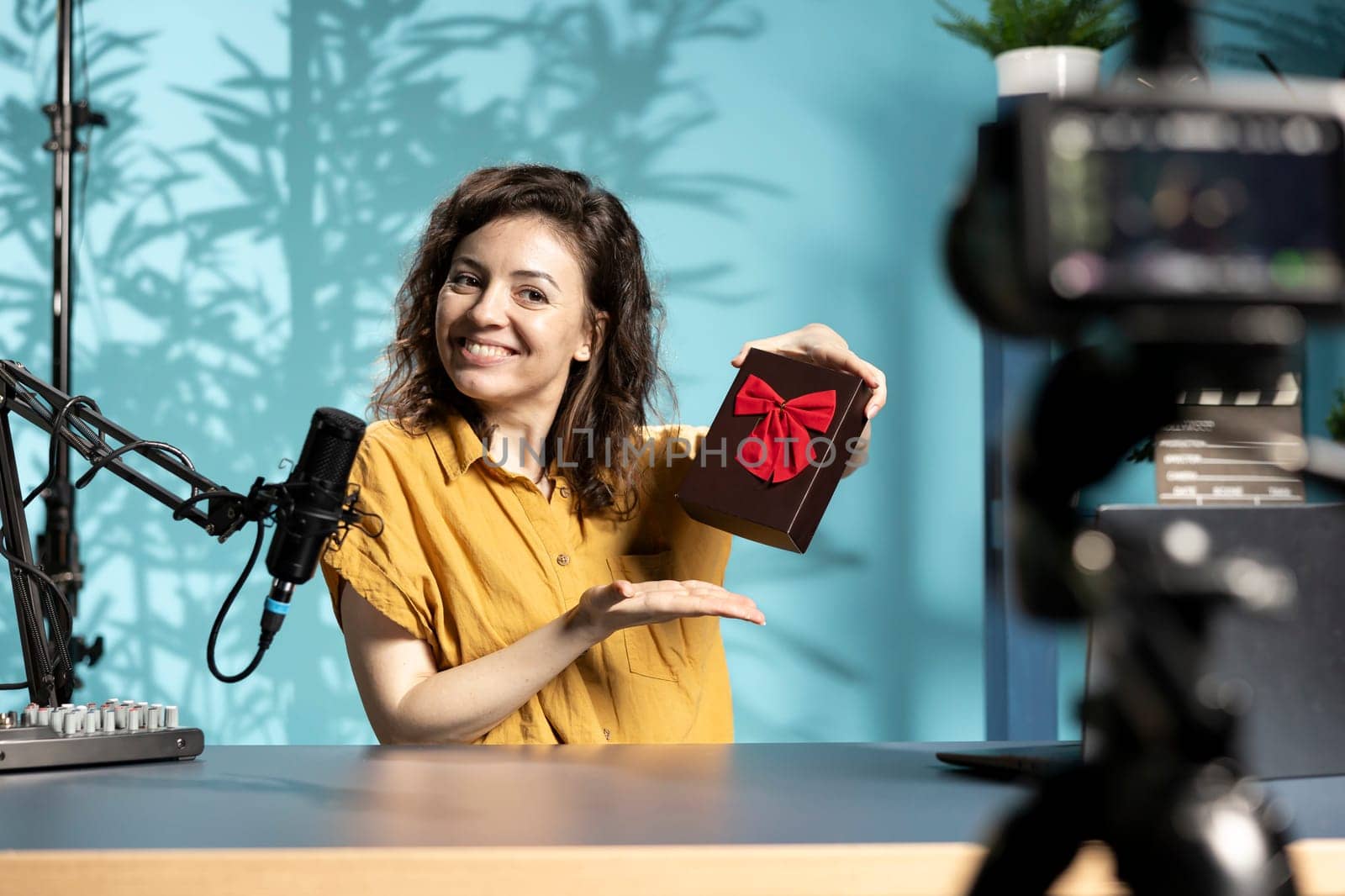 Vlogger holding giveaway for viewers, offering gift box, engaging with audience to drive engagement and increase participation. Content creator organizing contest, explaining rules and prize details