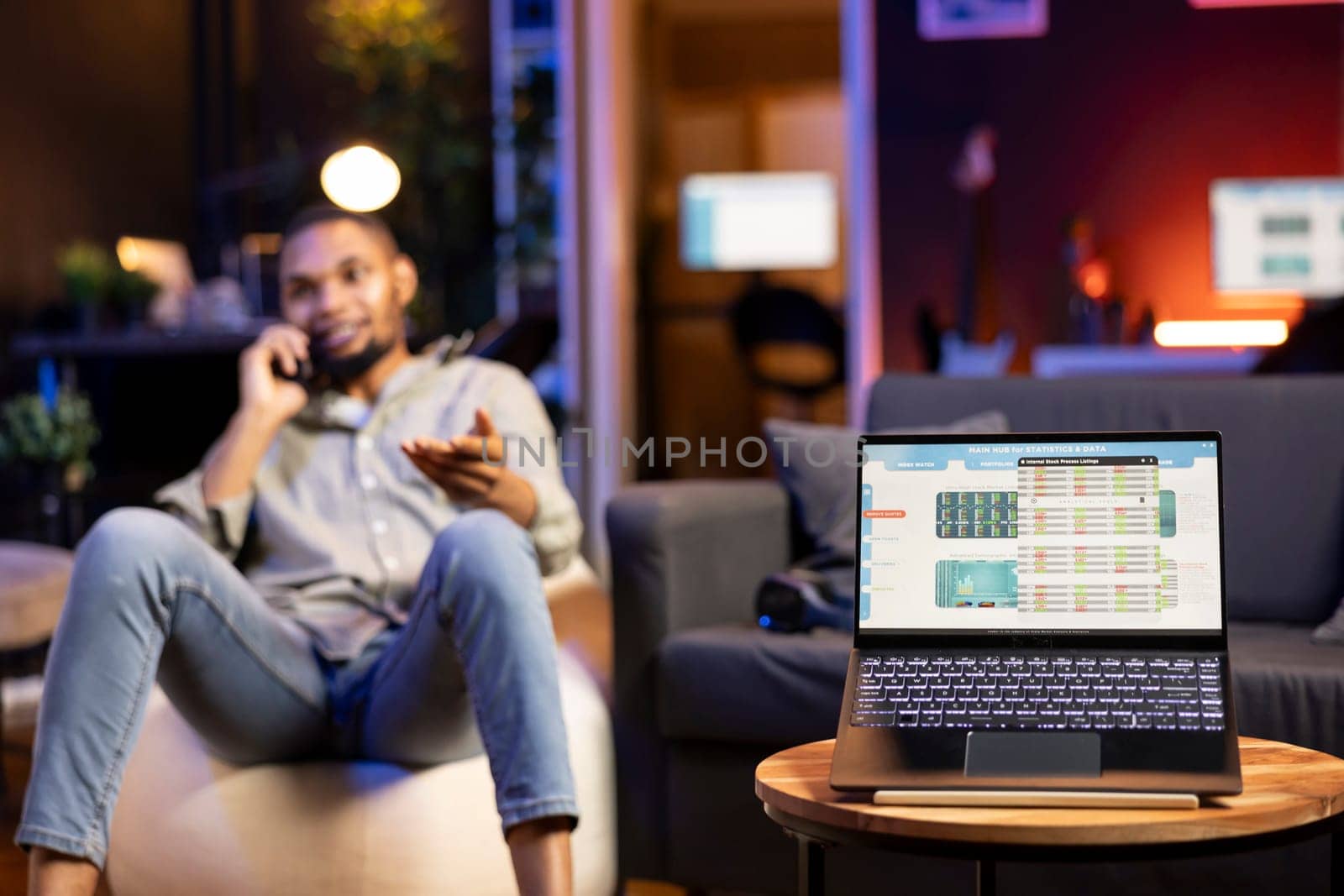 African American trader works from home using laptop to study stock prices, monitoring candlestick charts and exchange rates. Young focused investor analyzes profit and market liquidity.