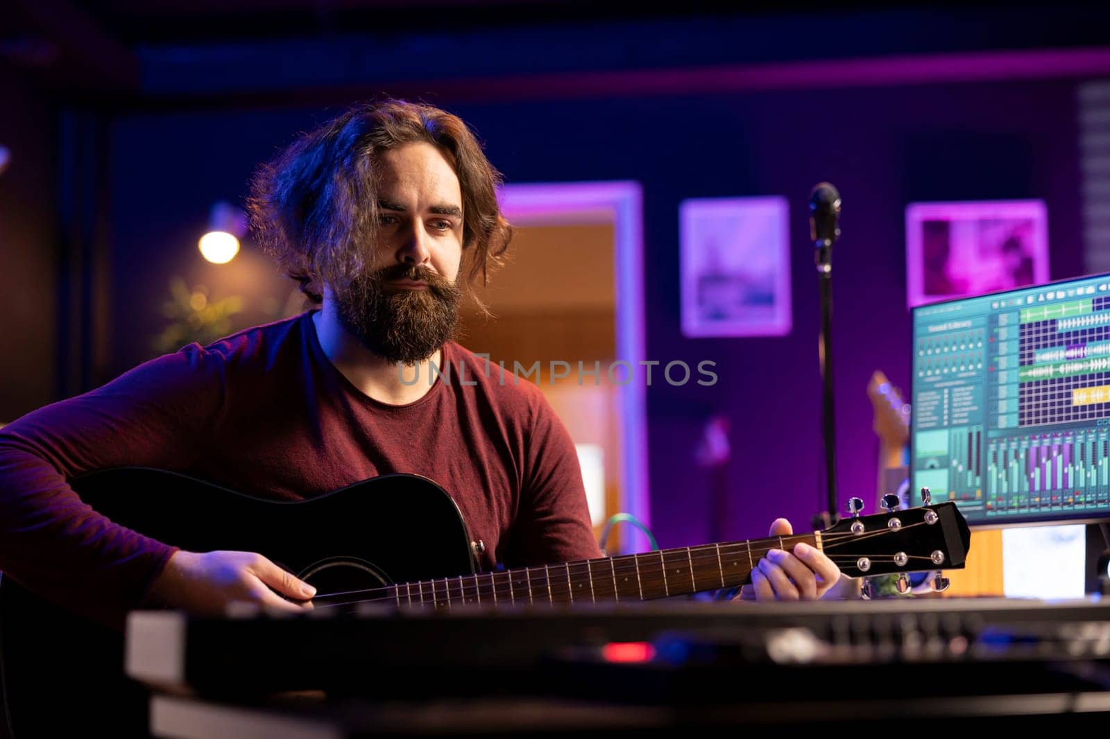 Musician plays acoustic guitar and records melody to compose new song and tunes. Computer screen showing DAW software interface with soundtracks, sound engineer in music production. Camera A.