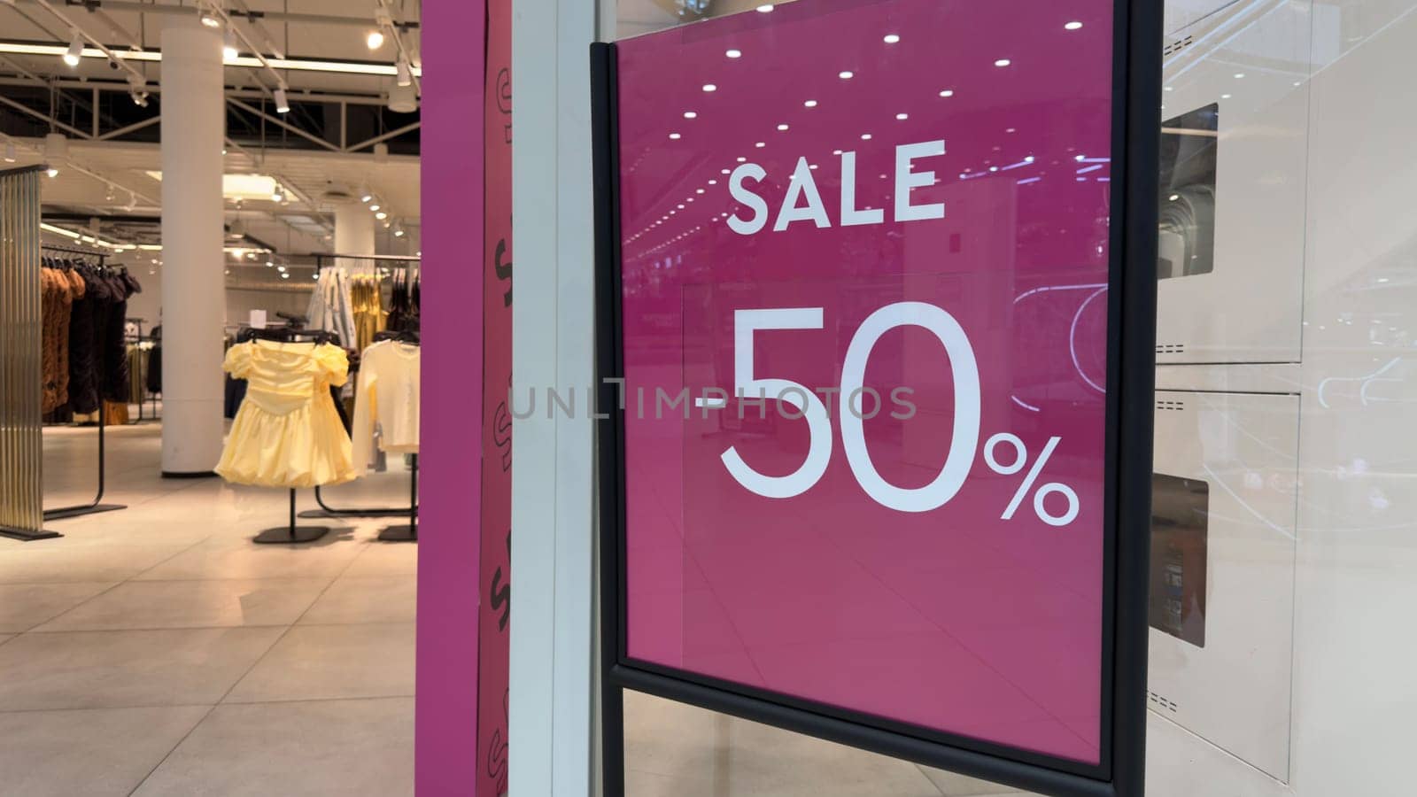 Big sale in clothing store. Prices in store are halved. Luring customers with big discount. Sale 50 percent in clothing and accessories shop. Marketing and attracting new customers with discounts