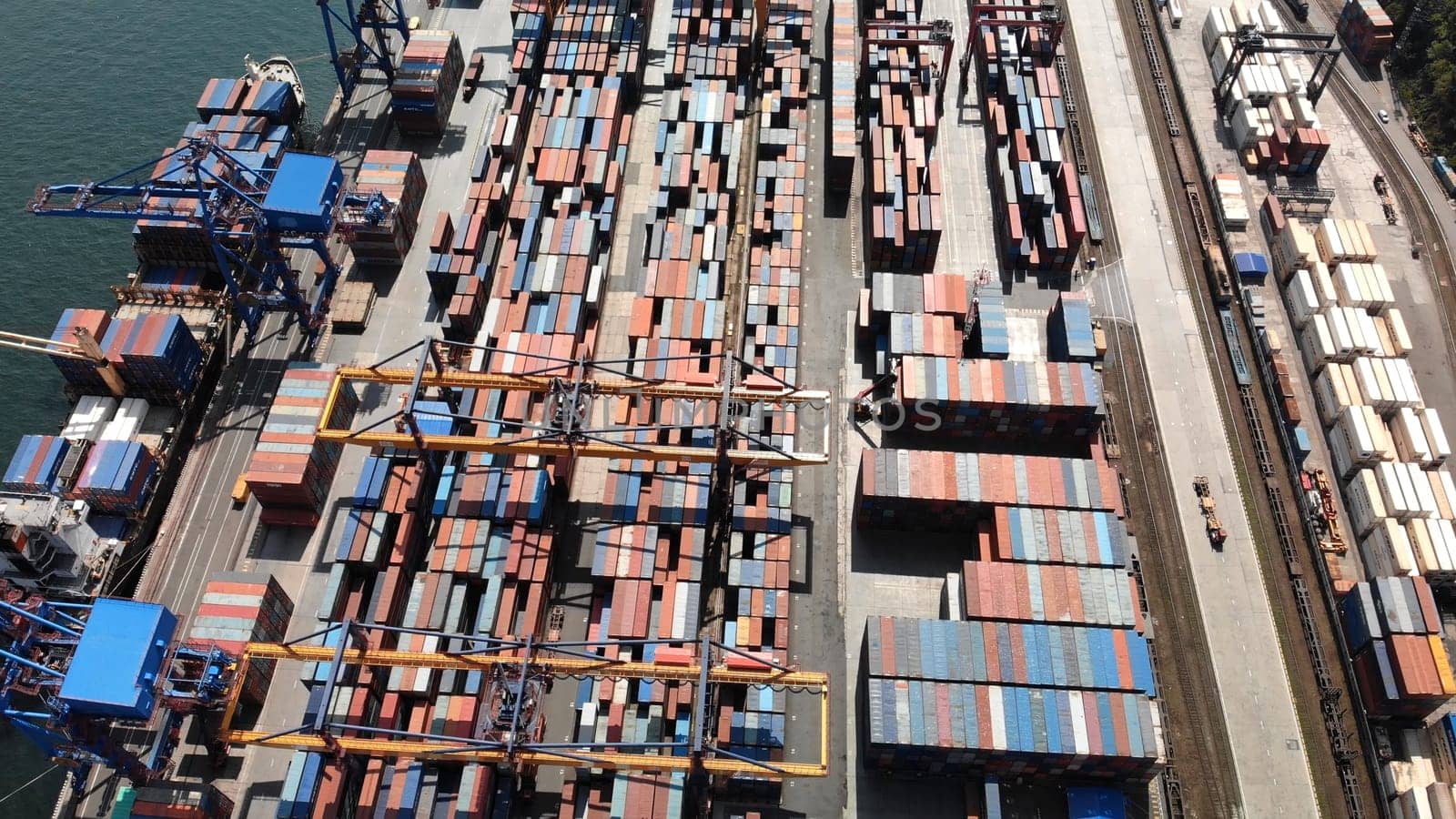 Aerial view of a container ship being loaded at a busy port, showcasing global trade and logistics operations