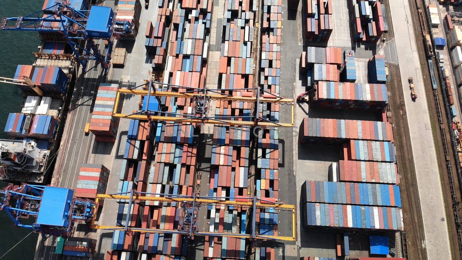 Aerial view of a container ship being loaded at a busy port, showcasing global trade and logistics