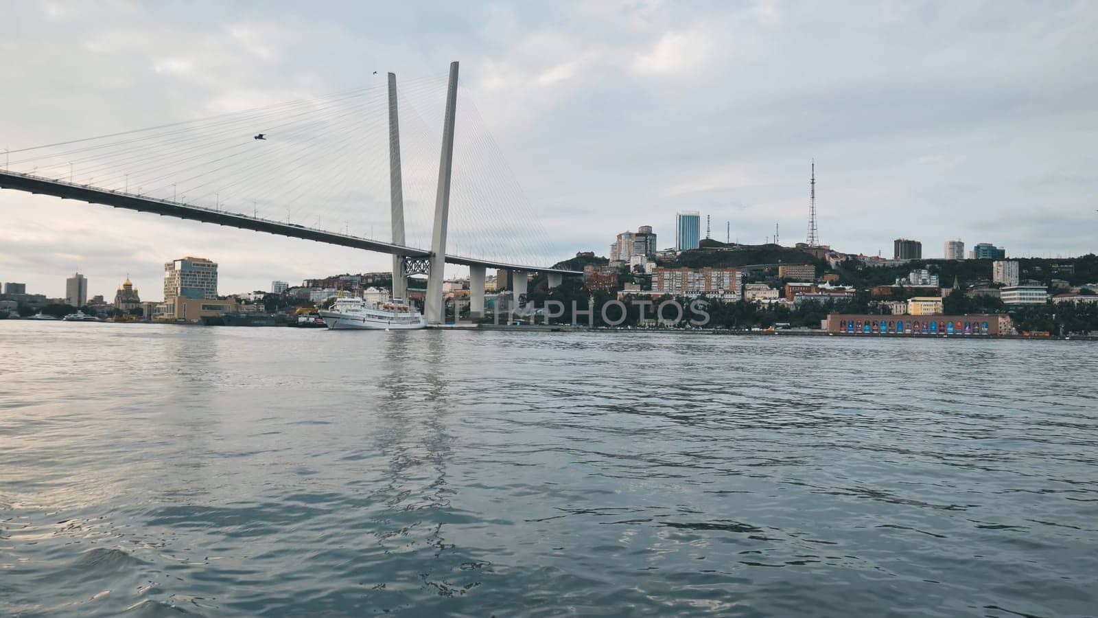 Golden bridge spanning zolotoy rog bay, highlighting vladivostok's urban landscape against scenic waterfront background