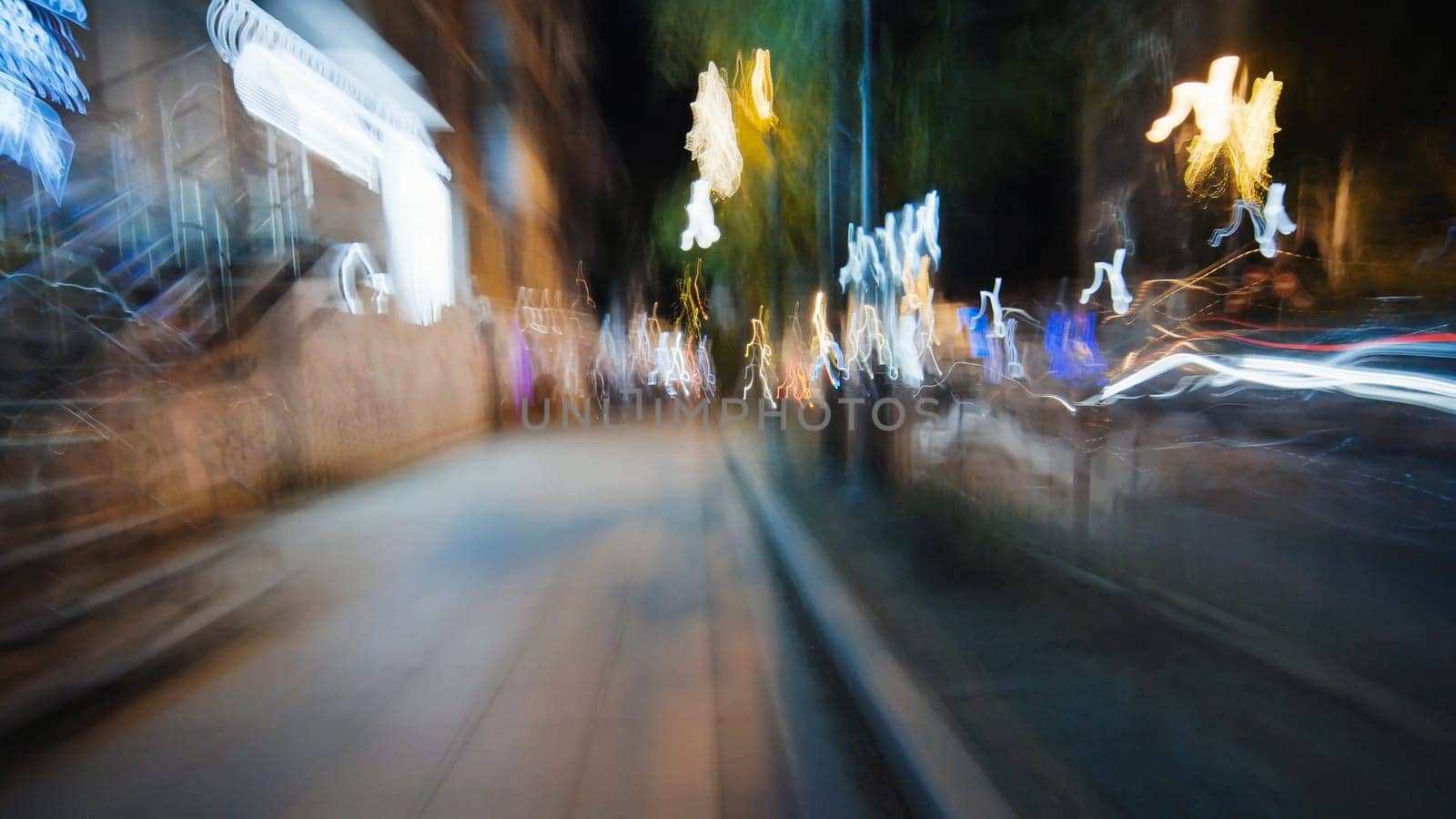 City street engulfed by luminous light trails, generating abstract nocturnal motion blur against dark urban backdrop