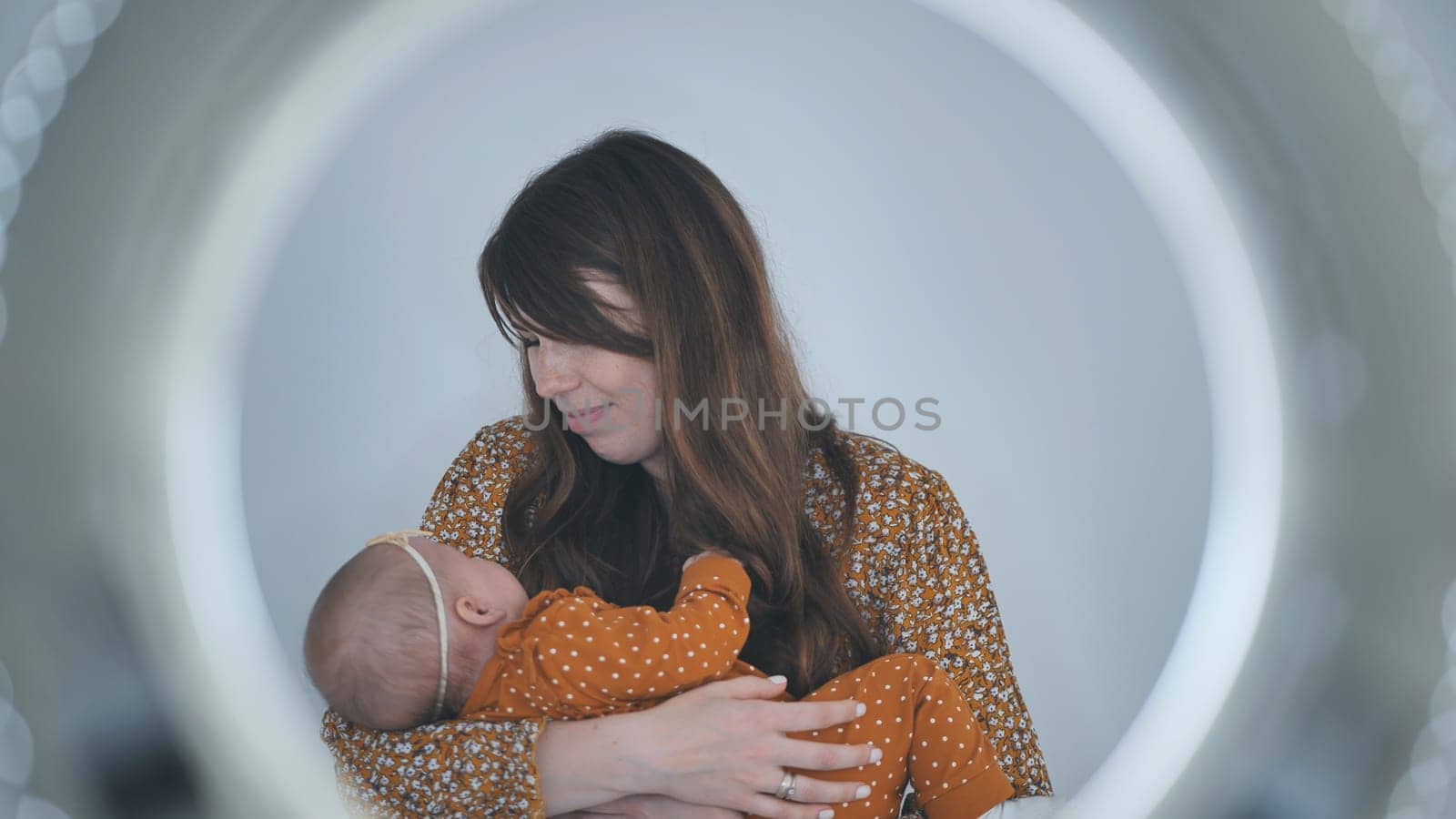 Soft circular lighting highlighting maternal warmth, mother gently holding sleeping newborn daughter close to her heart