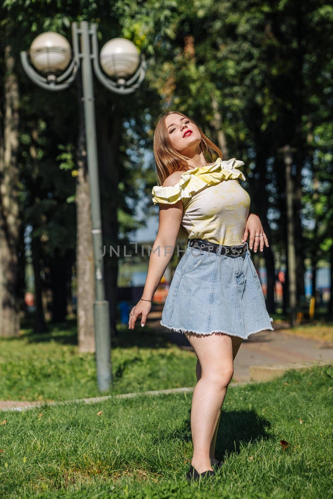 Cheerful female dancing outdoors, spinning with joy during sunlit summer afternoon, radiating youthful energy and freedom