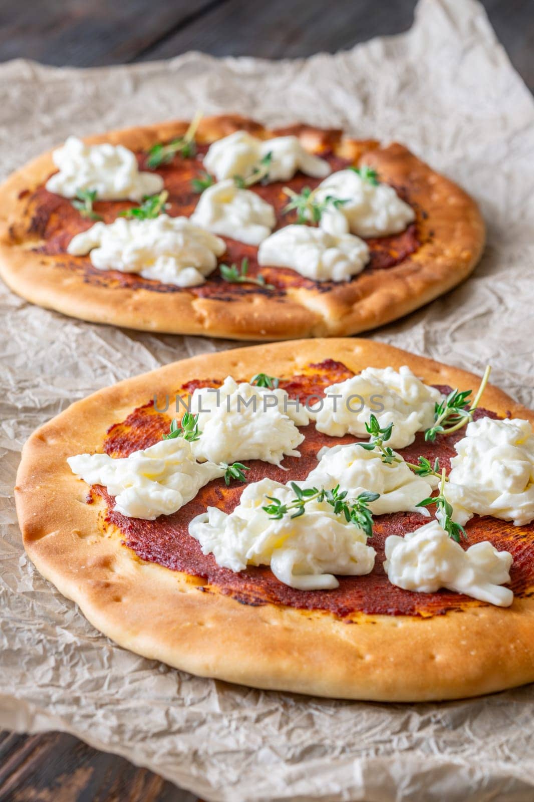 Golden crusts cradle warm stracciatella and sauce, accented with sprigs of thyme
