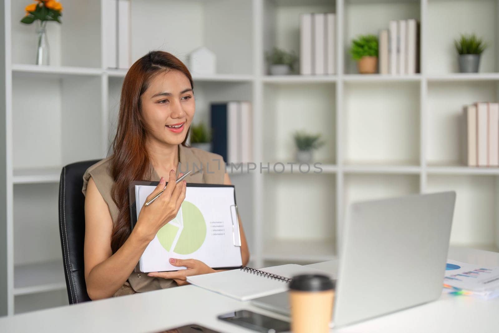 A confident businesswoman leads a virtual presentation, engaging her audience with insightful data insights, showcasing professionalism and effective online communication.