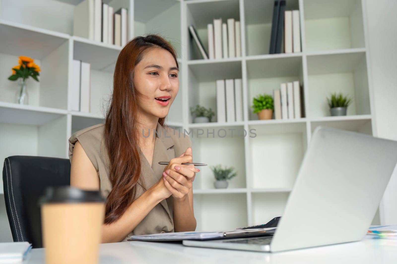 A young professional engages in a video conference, showcasing excitement and involvement while discussing important topics, emphasizing modern remote work practices.