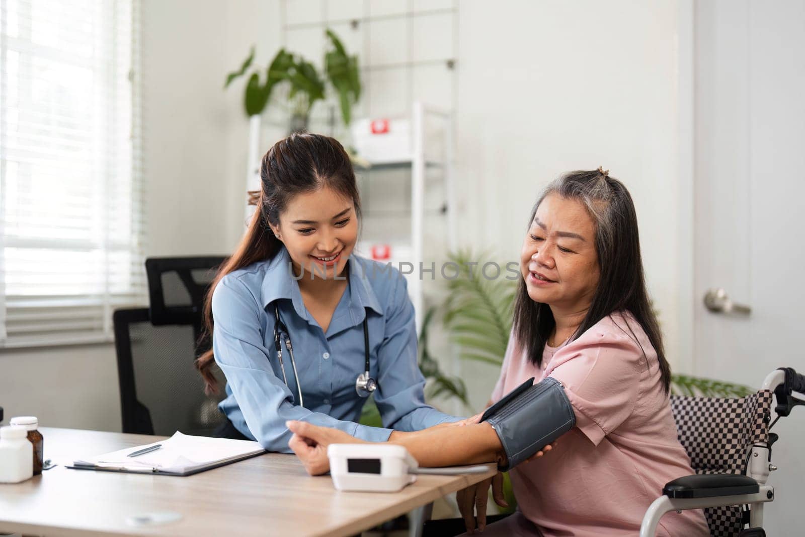 A nurse engages with an elderly patient, checking her blood pressure and discussing medication in a warm healthcare setting, ensuring her well-being.