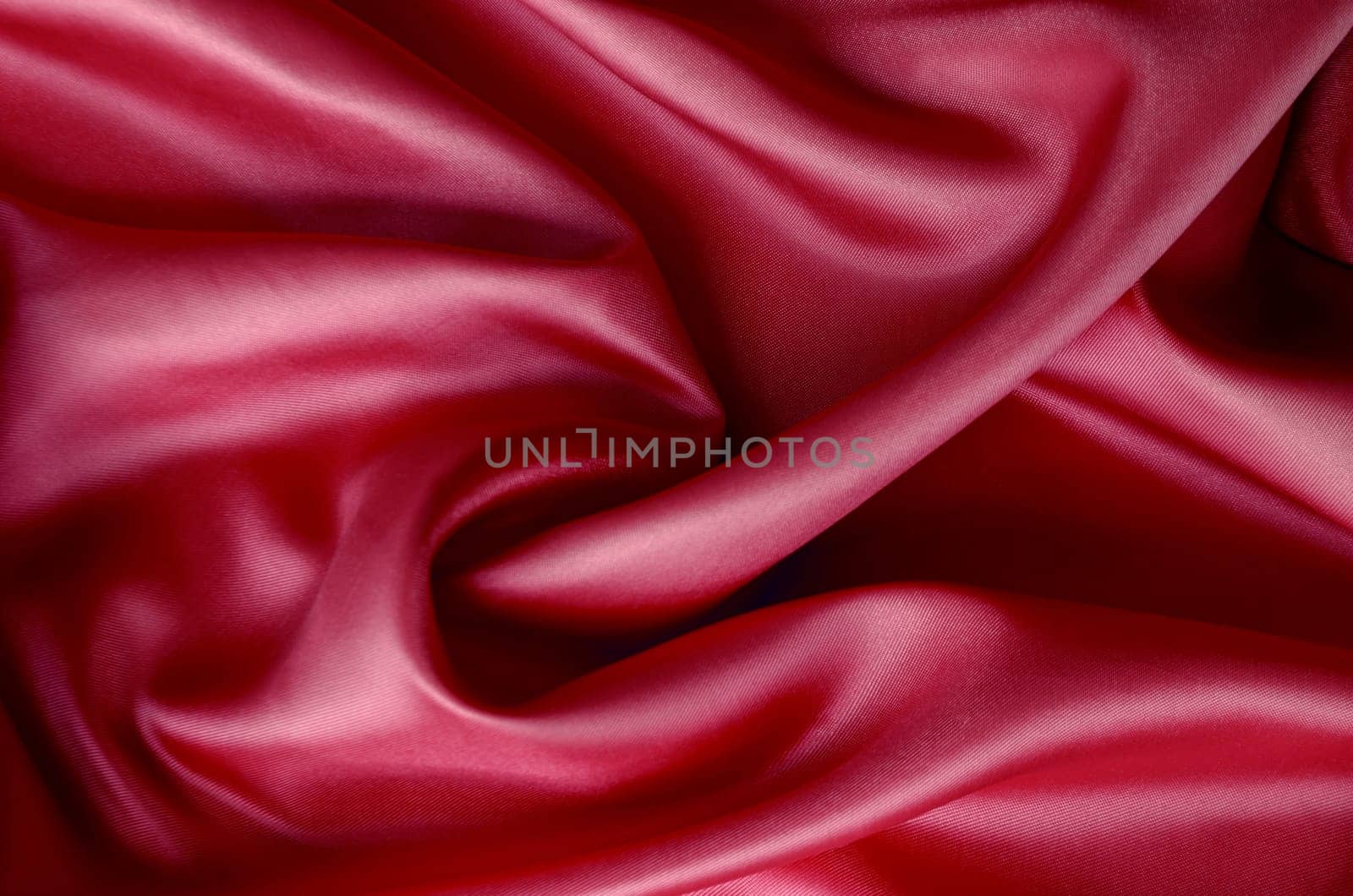 Dark red silk with soft curves and vibrant reflective surface. Suitable for design and wallpaper background.