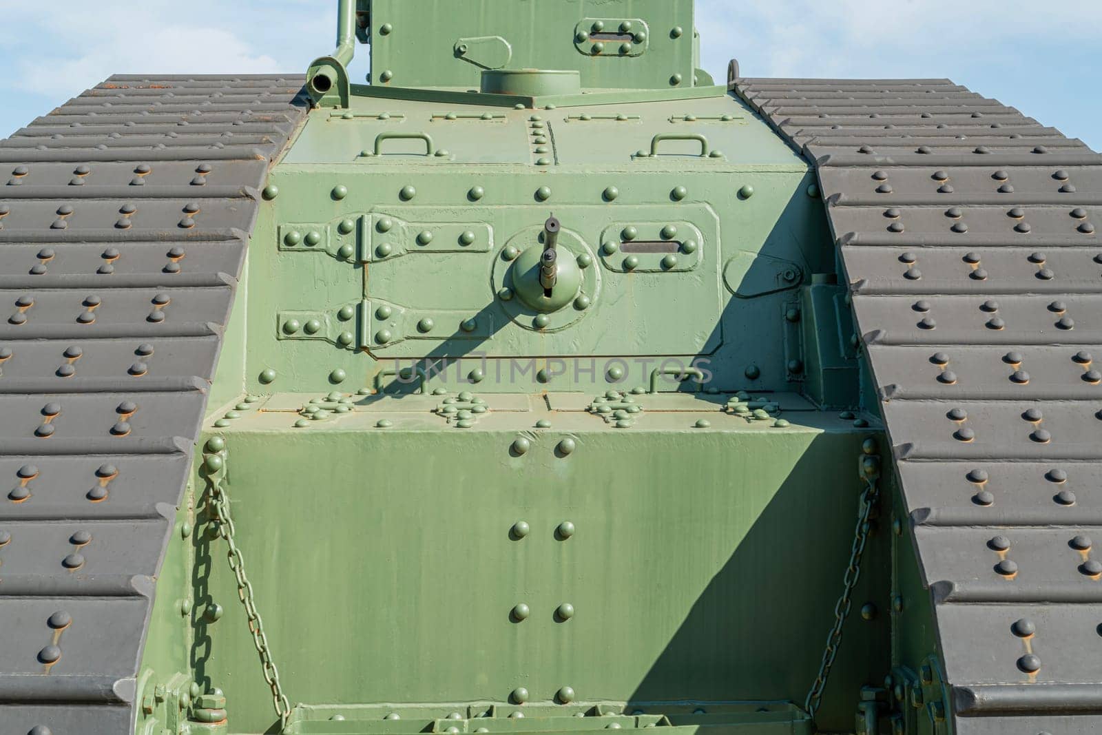 Bright sunlight reveals the intricate details of a military tank's armor design.