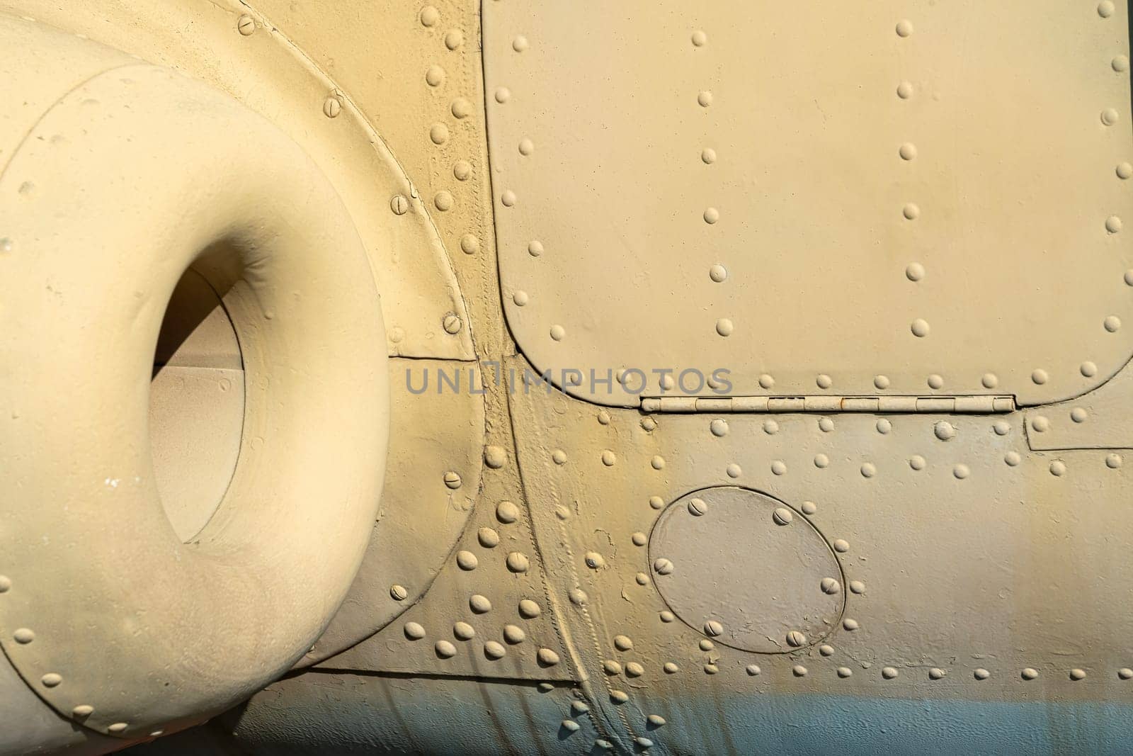 Fuselage of a military aircraft showcases intricate details and textures, highlighting rivets, access panels, and structural elements.