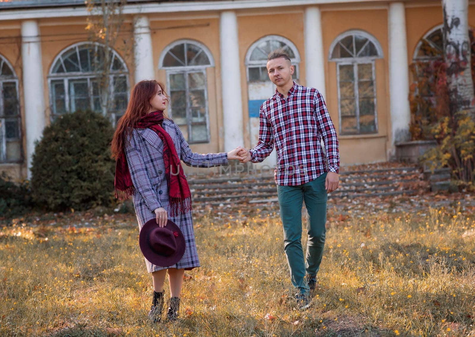 Happy young couple in love in autumn coats spending time together in autumn park, hugging. Romantic couple enjoying moments of happiness in city park. Love and tenderness, dating, romance. they are holding hands