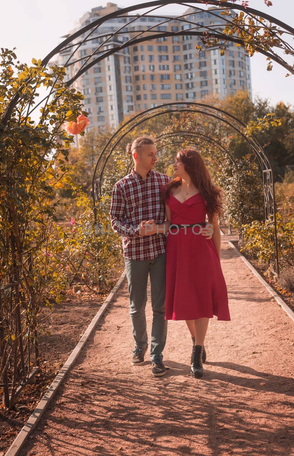 Happy young couple in love in autumn coats spending time together in autumn park hugging. Romantic couple enjoying moments of happiness in city park. Love and tenderness, dating, romance. Lifestyle concept