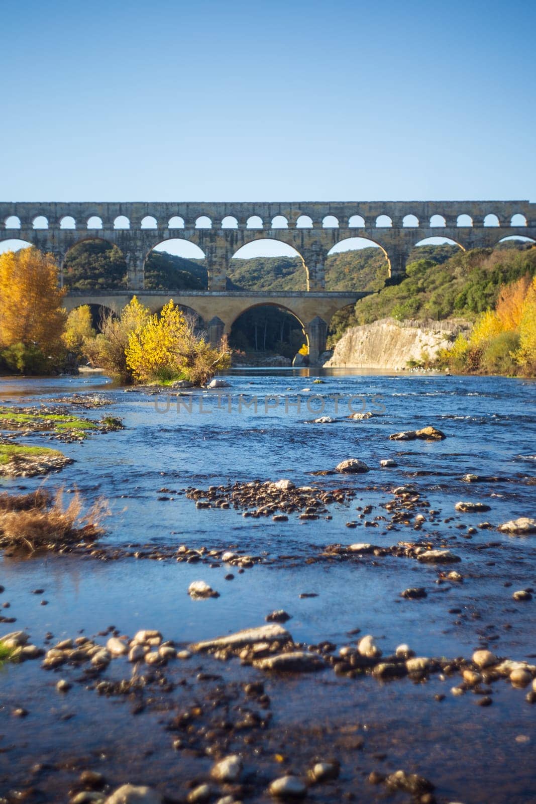 Vers-Pont-du-Gard, France - November 21, 2023:  Vertical photograph of the Pont du Gard over the Gardon River, in Provence, southern France. - Photo by WillyMobilo