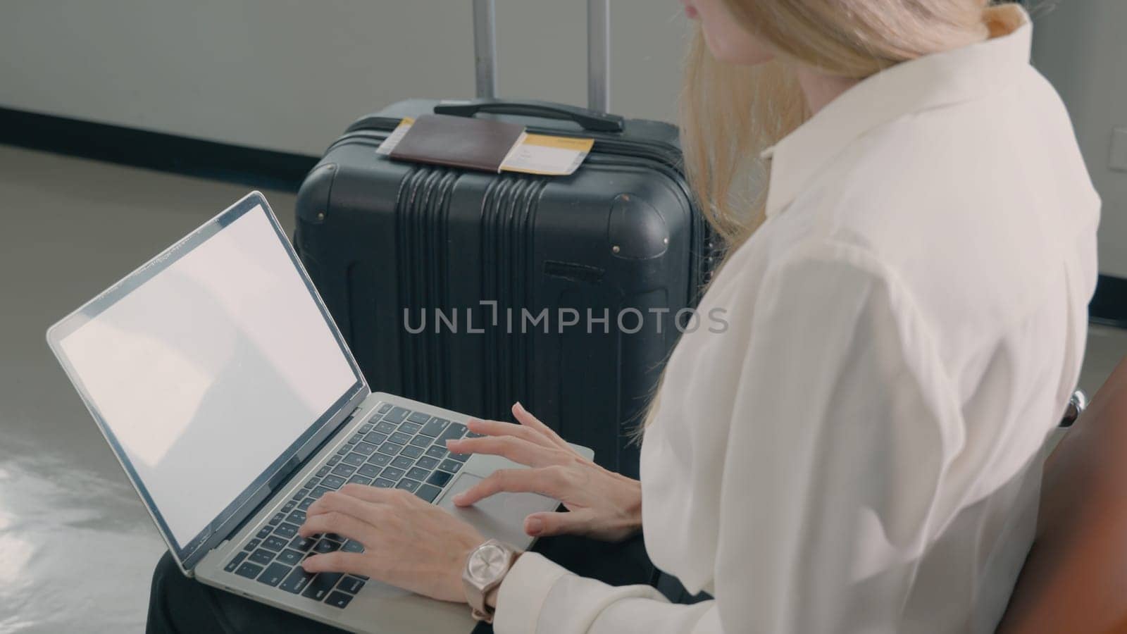 Passenger traveler woman in airport gate working laptop while waiting boarding air before vacation travel, female sitting and using notebook computer in terminal hall while wait for traveling flight