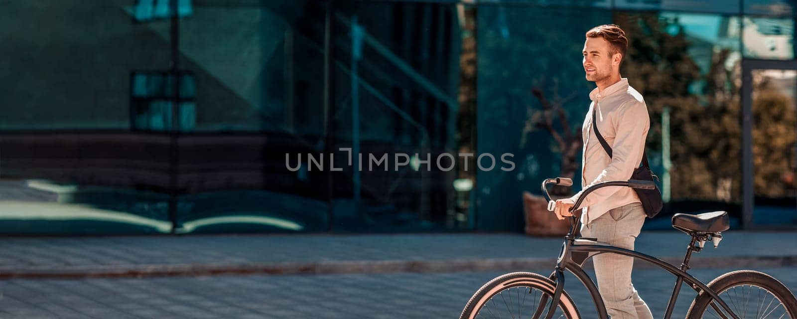 Transport, lifestyle and activity. Guy in formal clothes goes with bike in city, side view, panorama, copy space