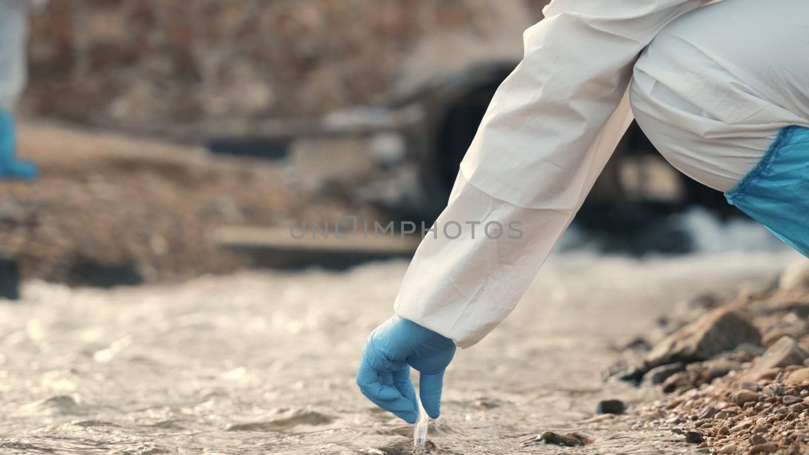 Ecologist sampling water from the river with test tube, Biologist wear protective suit and mask collects sample of waste water from industrial, problem environment, scientist environmentalist