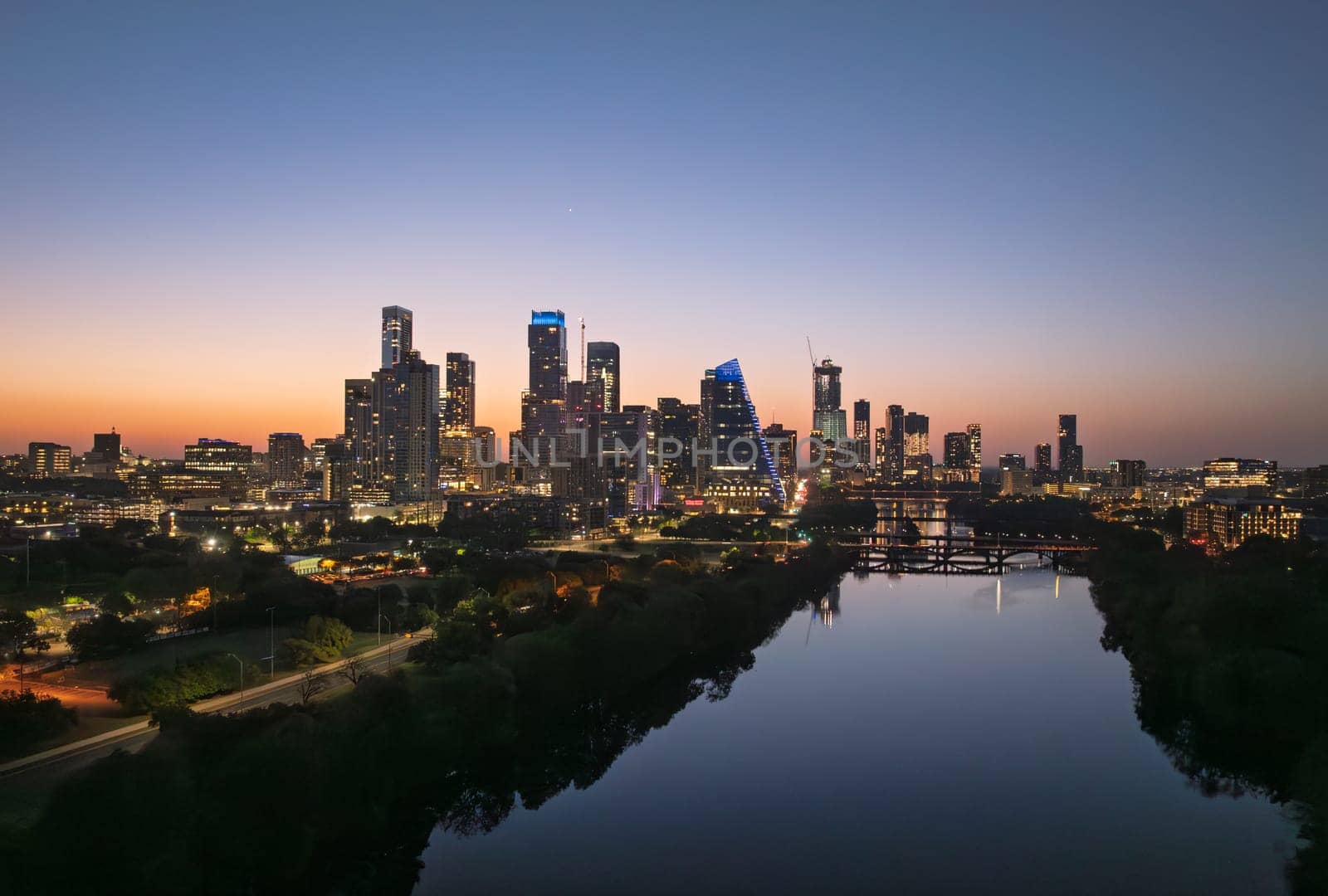 Brilliant orange and red sky behind the illuminated city skyline of Austin Texas before sunrise dawn