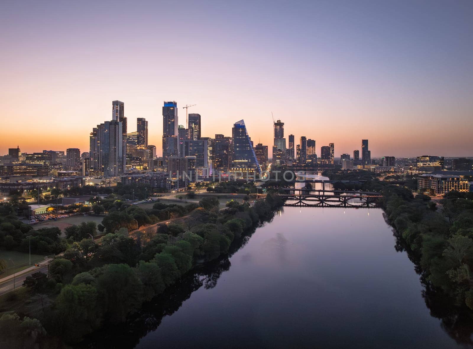 Brilliant orange and red sky behind the illuminated city skyline of Austin Texas before sunrise dawn
