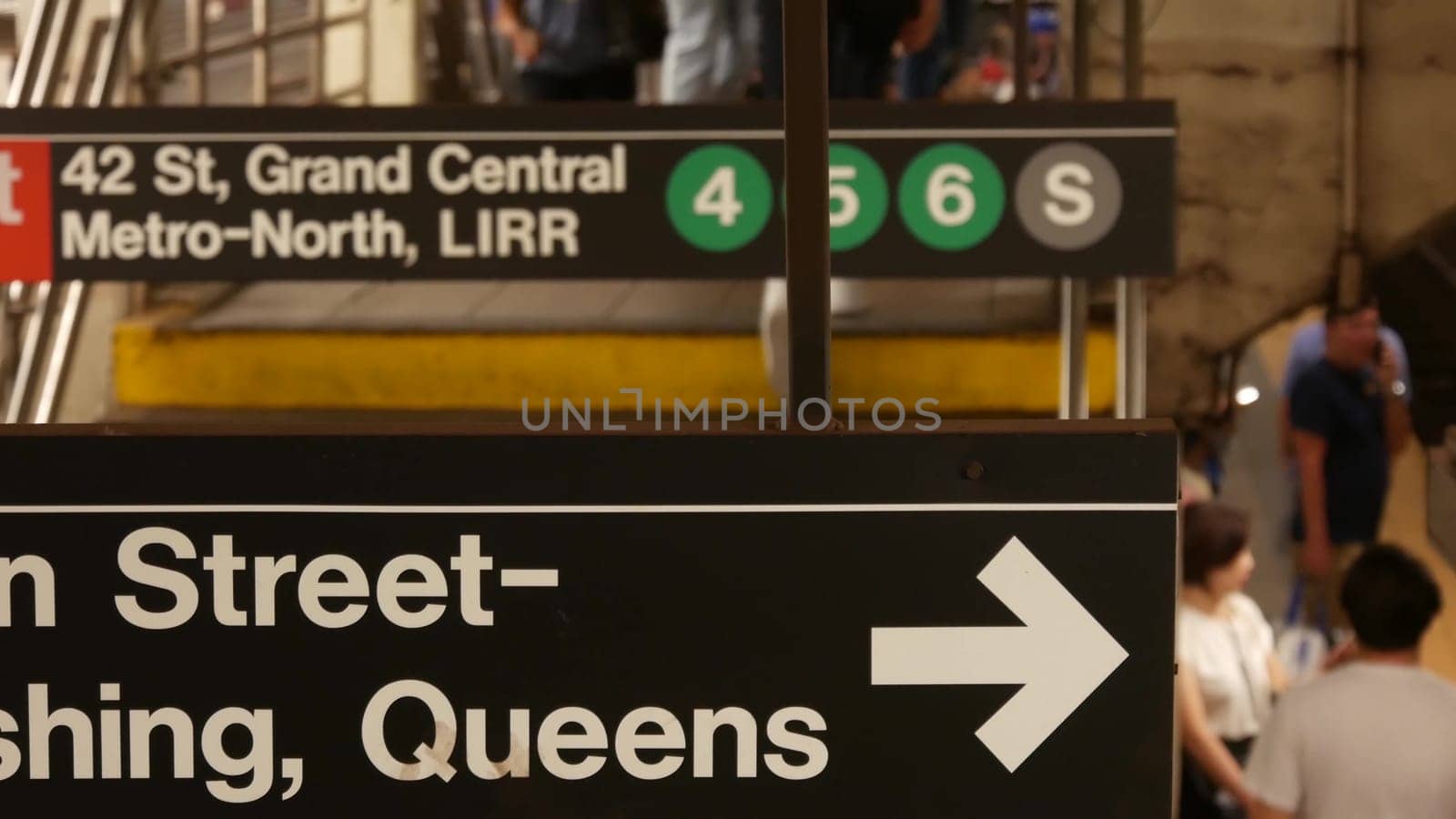 New York City, United States - 29 Aug 2023: Subway station interior, underground metropolitan platform. Public metro transport. Railway passenger traffic. Text sign: Grand Central, 42, Queens. People.