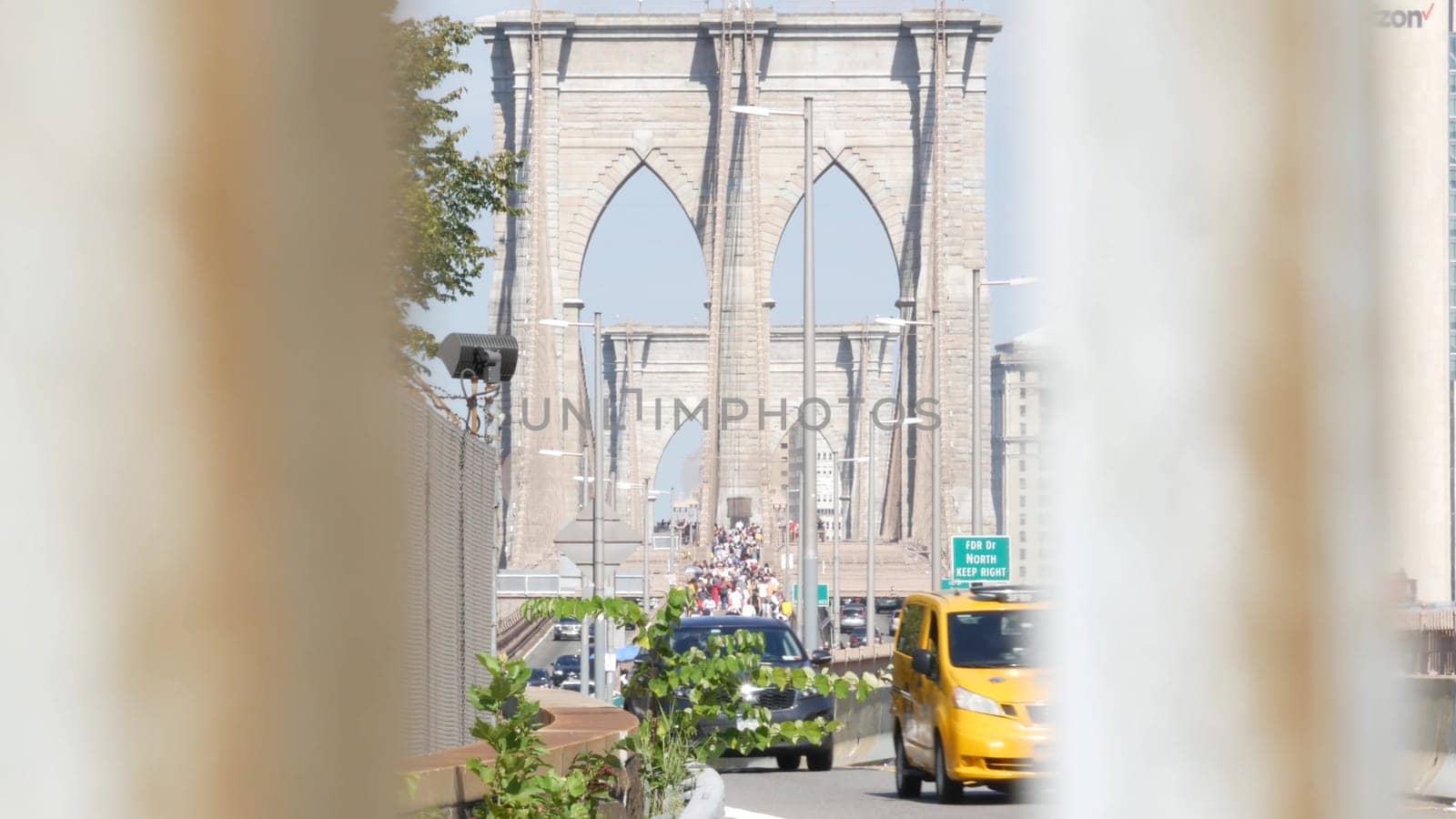New York City, United States - 3 Sept 2023: Cars on Brooklyn Bridge from Manhattan downtown to Dumbo. Financial district skyline cityscape. Road traffic, people walking and USA architecture.
