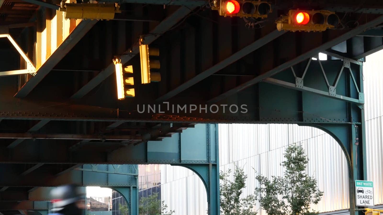 New York City, United States - 2 Sept 2023: Elevated subway, metropolitan bridge, metro track above street. Railway transport over road. Queens old railroad line, Long Island. Yellow traffic light.