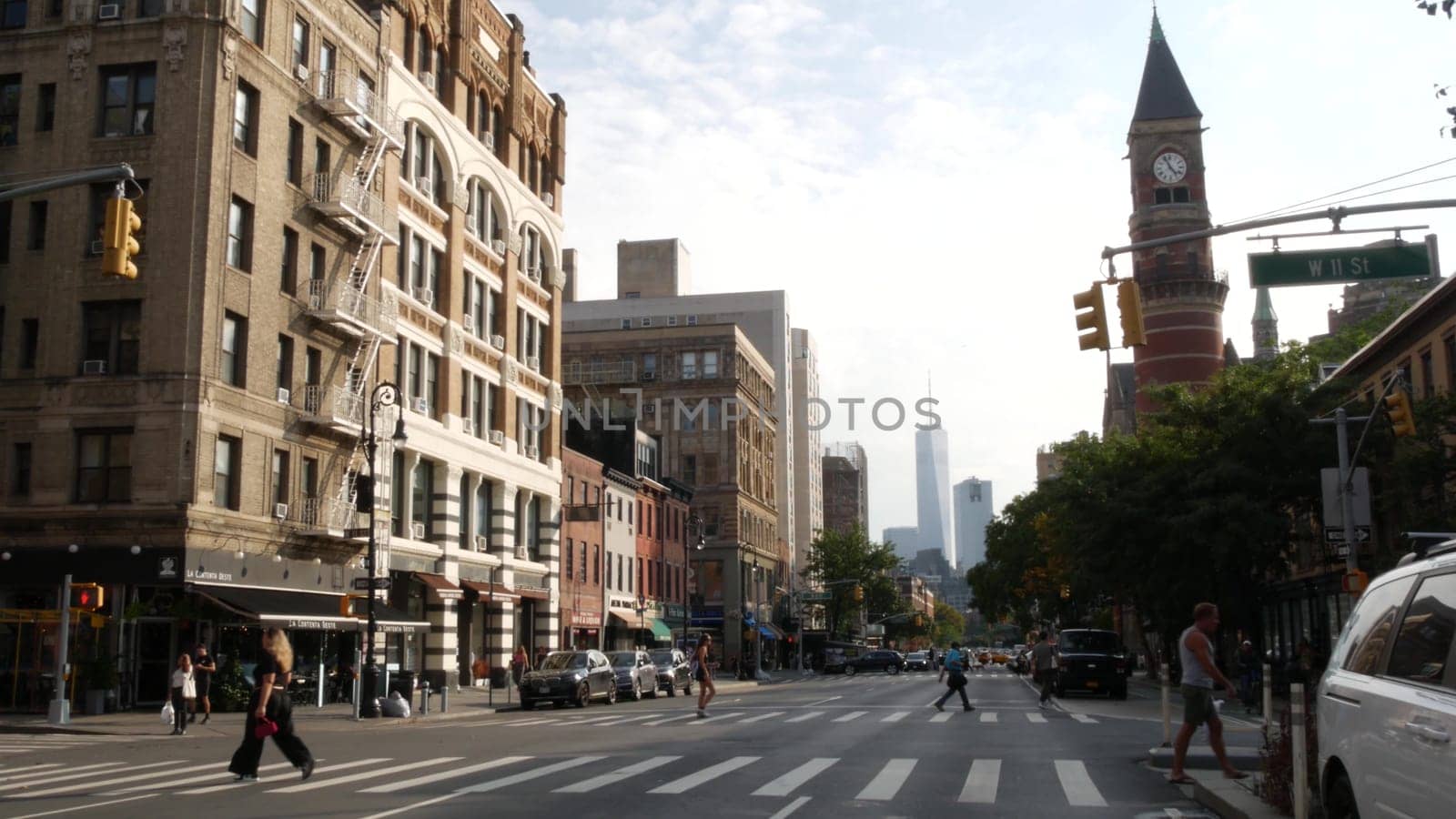 New York City, United States - 10 Sept 2023: Manhattan Greenwich Village street, Sixth 6 Americas avenue crossroad. Road traffic. People, USA World trade center. Jefferson Market Library, clock tower.