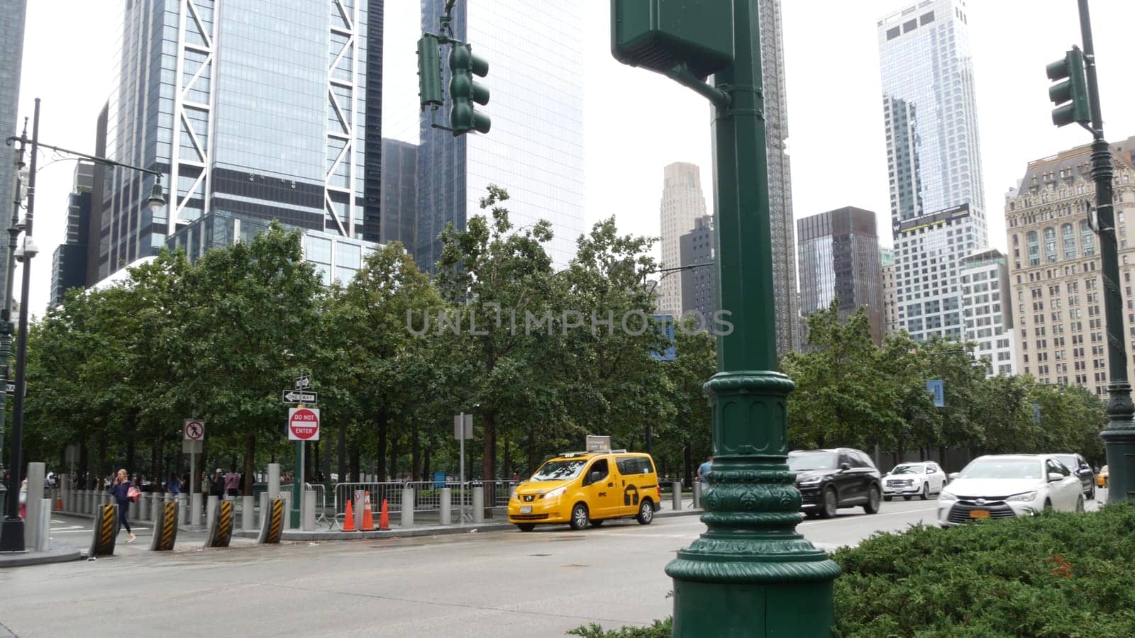 New York City, United States - 10 Sept 2023: Manhattan Downtown Financial District street crossroad intersection. Urban road car traffic. People pedestrian. World Trade Center. Yellow taxi cab.